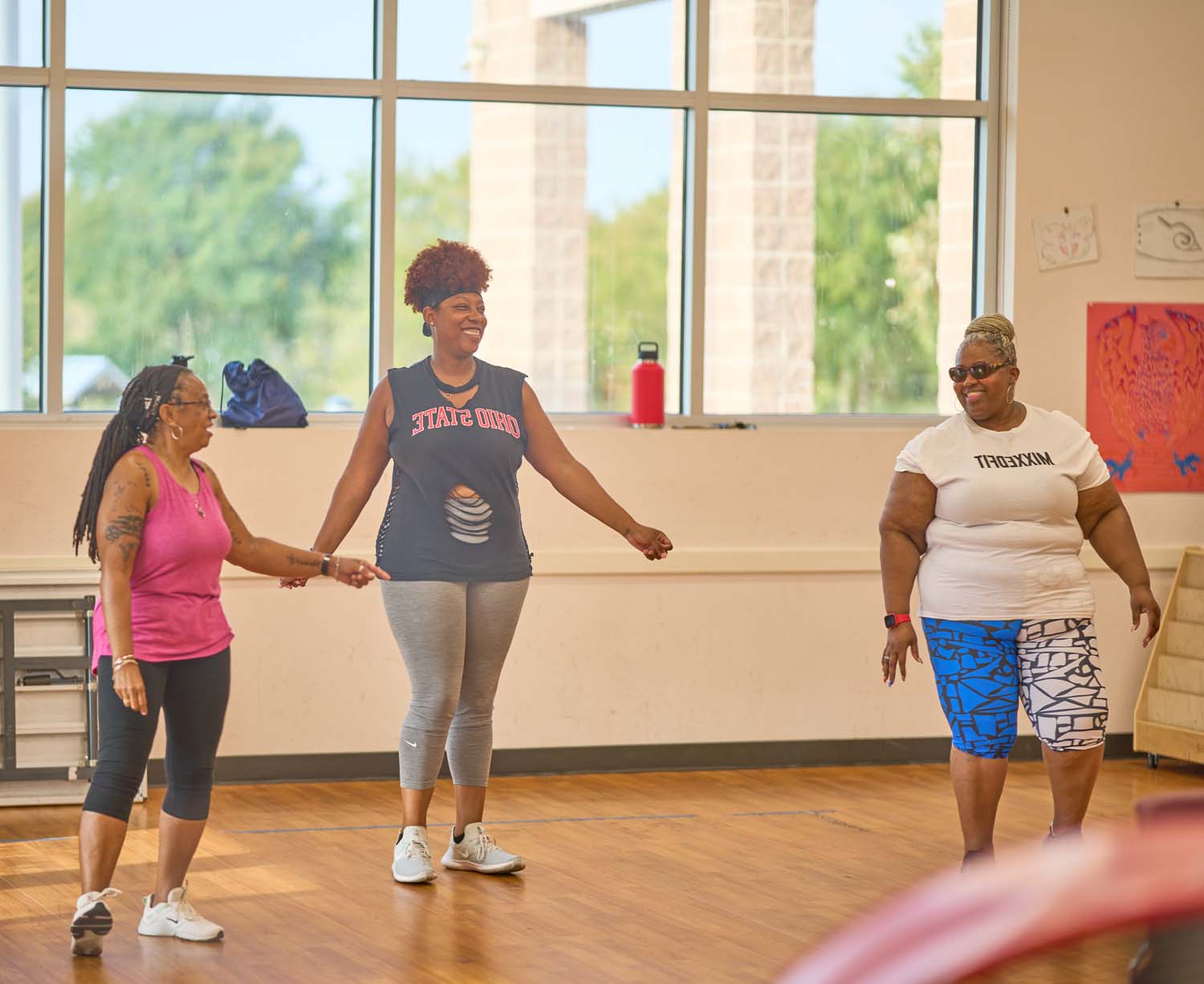 Three women participating in a Stronger Texas fitness class